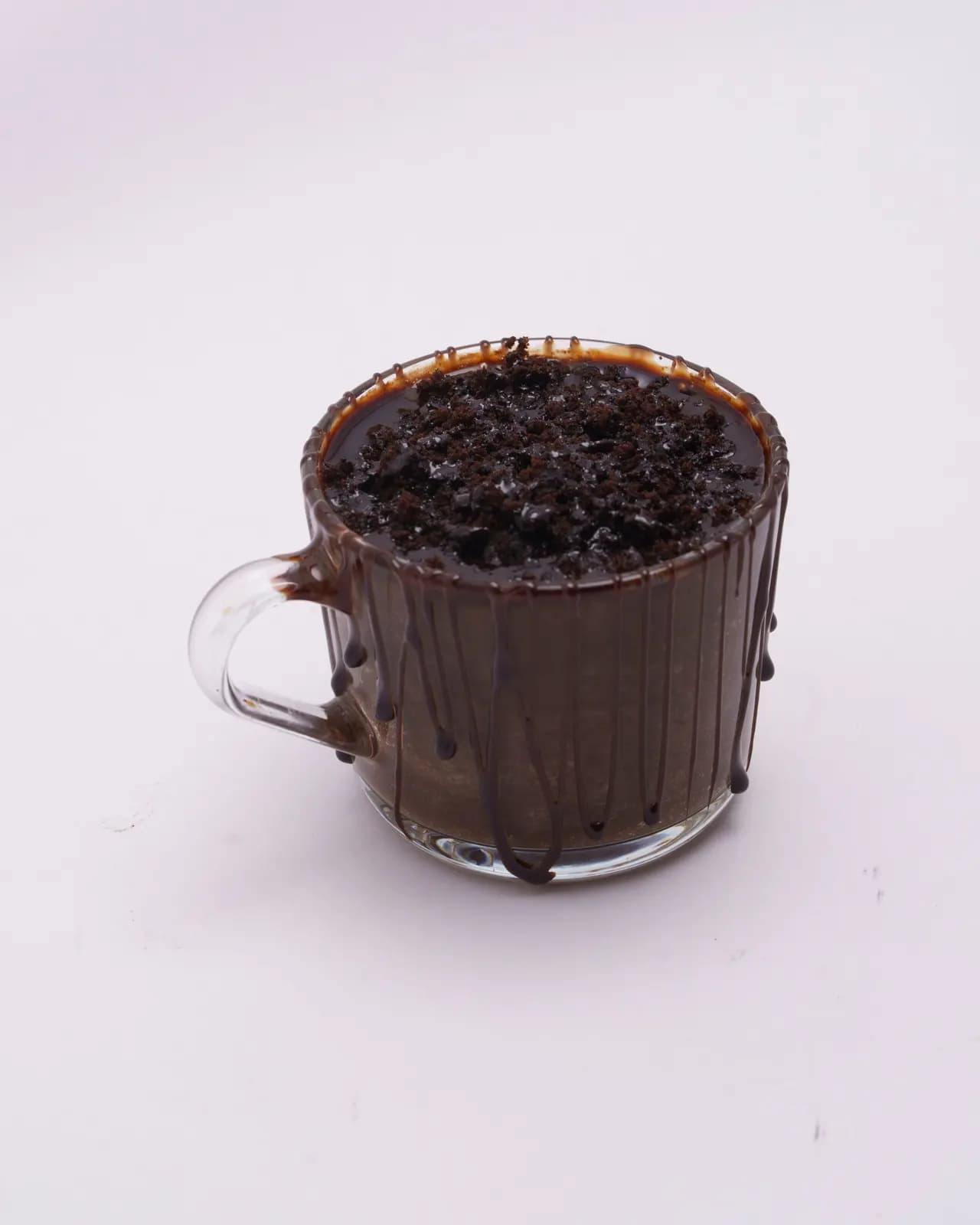Chocolate mug cake in a clear glass mug, glossy with melted chocolate on top