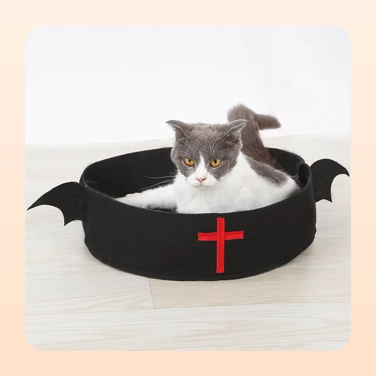 The Kindral bat-wing felt cat bed on a wooden floor
