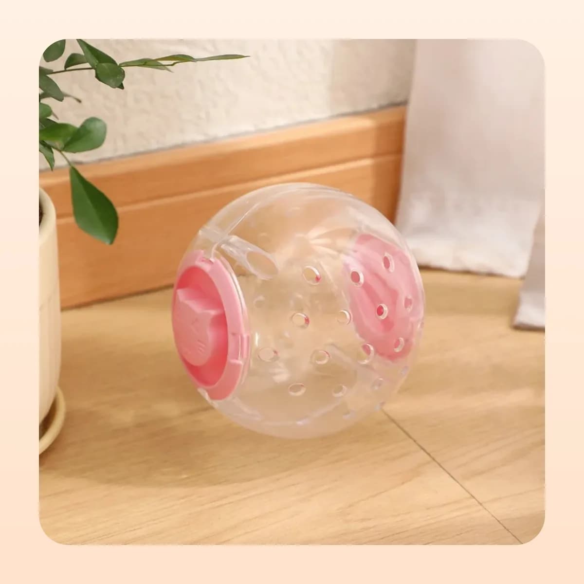 Kindral treat-dispensing ball with a pink lid