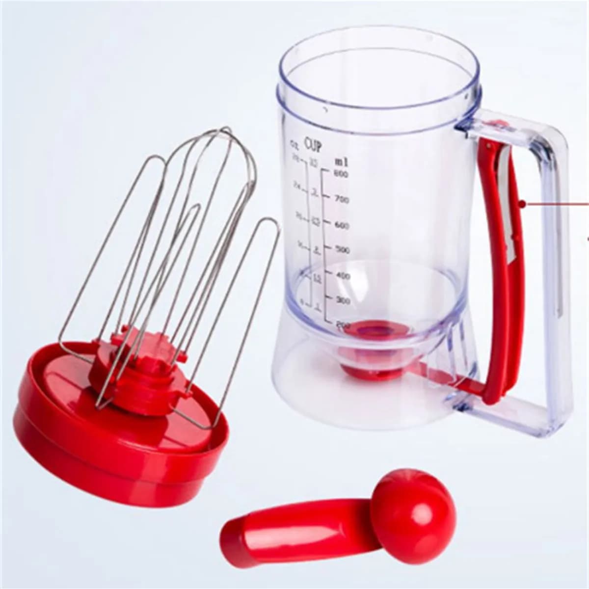 Kindral pancake batter dispenser in red and clear, taken apart: jug, whisk lid and crank