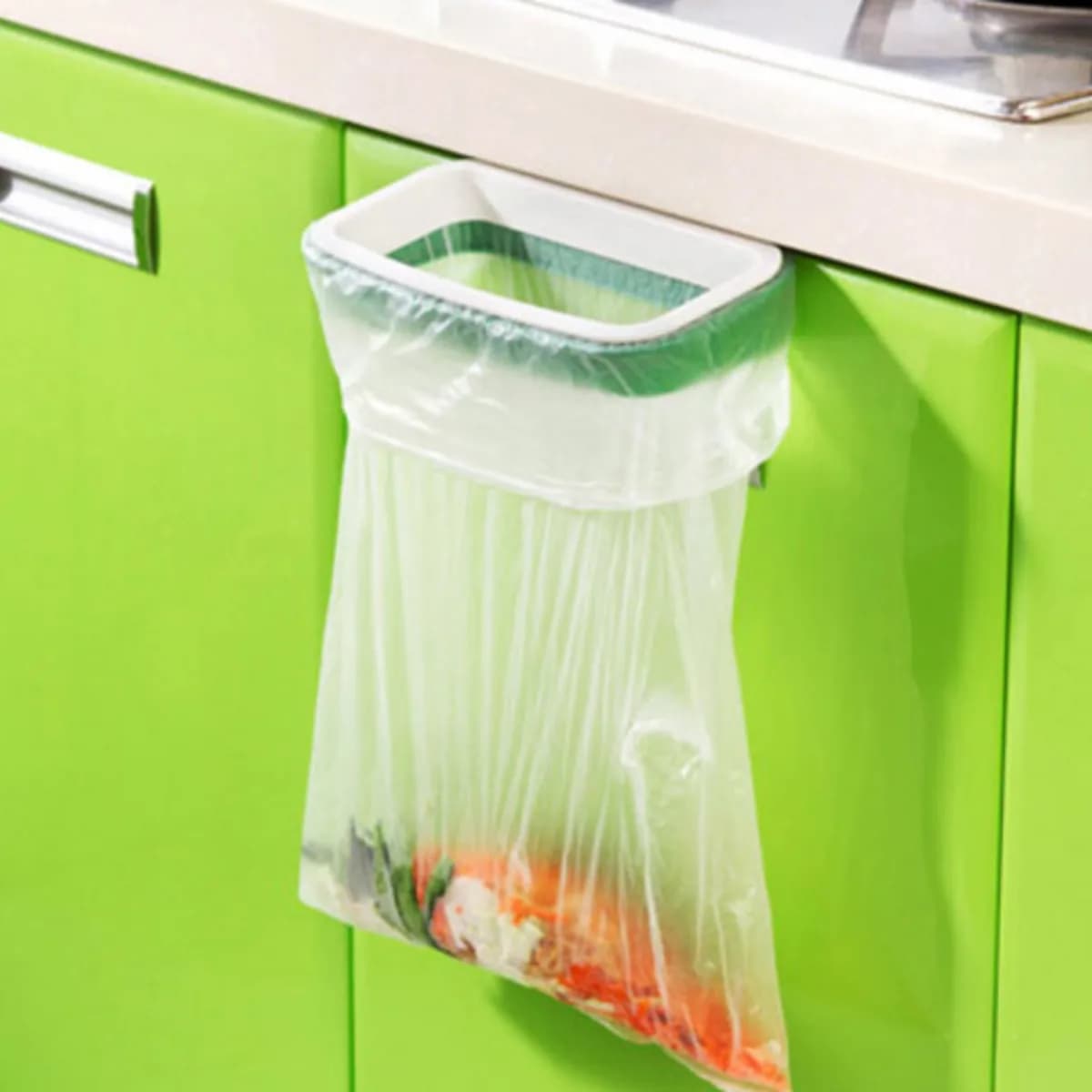 Kindral cupboard door bin bag holder in white and green, holding a bag of peelings